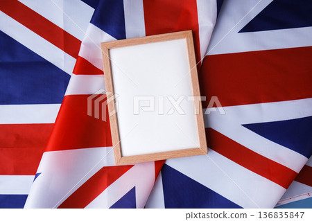 Empty white paper frame National symbol of Great Britain. Mock up advertisement template British wave UK fabric flag background. Copy space for your text. Independence Empty white paper frame National symbol of Great Britain. Mock up advertisement template British wave UK fabric flag background. Copy space for your text. Independence 136835847