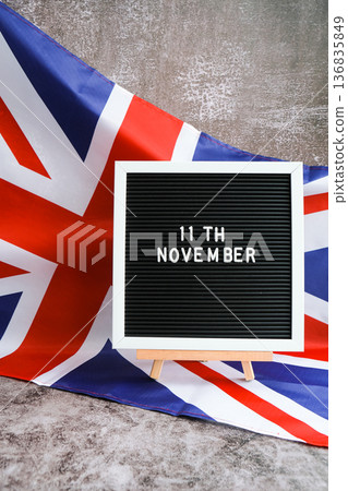 Minimal patriotic scene with signboard and waving flag date 11th November UNITED KINGDOM with national colors Festive background with British flag and message board with text Great Britain 136835849