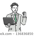 A young male businessman cheering with a smile while holding a laptop 136836850
