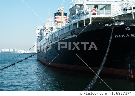 The hull of the Hikawa Maru shining against the blue sky. A view of the historic passenger ship that symbolizes Yokohama Port. The tranquility of Yokohama Port, woven together by the blue sea and the giant chain. The hull of the Hikawa Maru shining against the blue sky. A view of the historic passenger ship that symbolizes Yokohama Port. The tranquility of Yokohama Port, woven together by the blue sea and the giant chain. 136837174