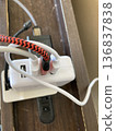 Multiple USB chargers and cables lined up on a desktop power strip 136837838