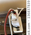 Multiple AC adapters and USB cables connected to a desktop power strip 136837839
