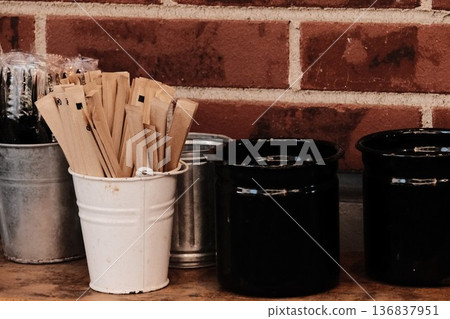 The cafe's self-service corner. Sugar sticks and cutlery stand out against the brick wall. The cafe's self-service corner. Sugar sticks and cutlery stand out against the brick wall. 136837951