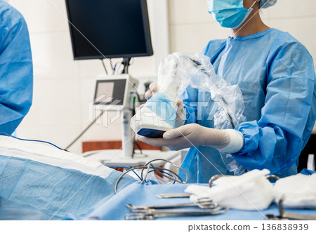 The surgeon uses a portable fluorescence imaging device during breast removal. The surgeon uses a portable fluorescence imaging device during breast removal. 136838939
