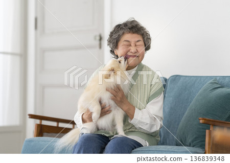 Senior woman holding her pet dog Senior woman holding her pet dog 136839348
