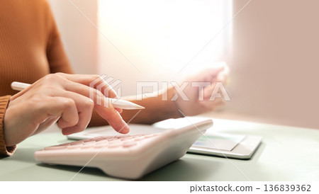 erson using calculator, representing personal finance management 136839362