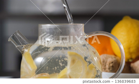 Herbal tea with lemon and ginger boiling in a glass teapot. Natural detox beverage for a healthy lifestyle concept  136839683