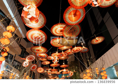 夜晚的城市裡懸掛著傳統的日式紙傘和燈籠。 夜晚的城市裡懸掛著傳統的日式紙傘和燈籠。 136839956