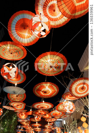 Traditional Japanese paper umbrellas and lanterns hanging in the city at night 136839961