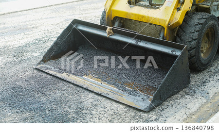 Shovel car sweeping up asphalt debris 136840798