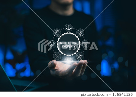 Intellectual property protection concept with businessman showing digital icons for copyright, patent, trademark, and legal rights, emphasizing innovation security in digital technology business. 136841126