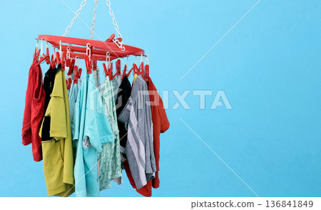 Colorful baby Clothes Hanging on Plastic Clip Hanger 136841849