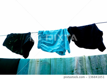 Clothes Drying on a Rope Against Blue Wall Outdoors Clothes Drying on a Rope Against Blue Wall Outdoors 136841851