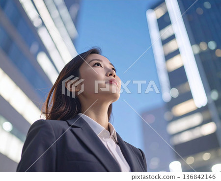 一位身穿西裝的女子仰望天空，邁向未來。 136842146