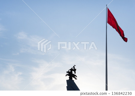 BISHKEK, KYRGYZSTAN - FEBRUARY 16, 2026. Silhouette of the Monument to Aikol Manas and the National Flag of Kyrgyzstan on Ala-Too Square. BISHKEK, KYRGYZSTAN - FEBRUARY 16, 2026. Silhouette of the Monument to Aikol Manas and the National Flag of Kyrgyzstan on Ala-Too Square. 136842230