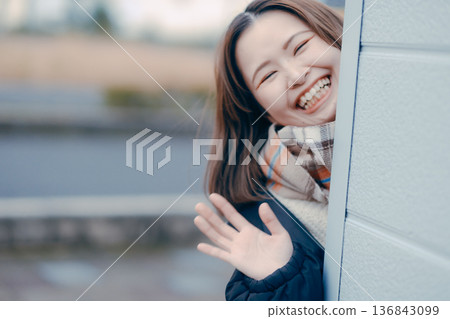 A Japanese woman in her twenties waving with a smile A Japanese woman in her twenties waving with a smile 136843099