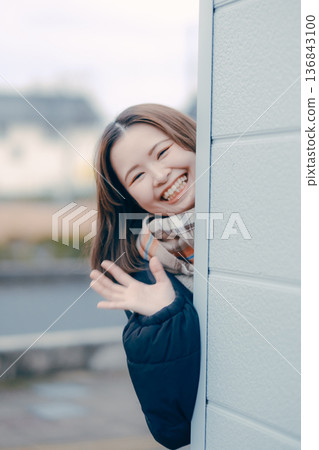 A Japanese woman in her twenties waving with a smile A Japanese woman in her twenties waving with a smile 136843100