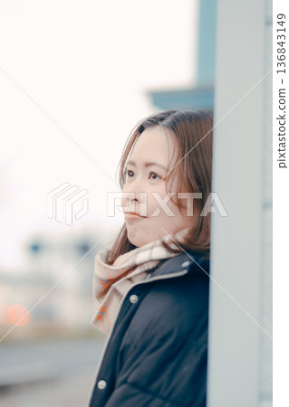Pensive young woman in the evening city 136843149