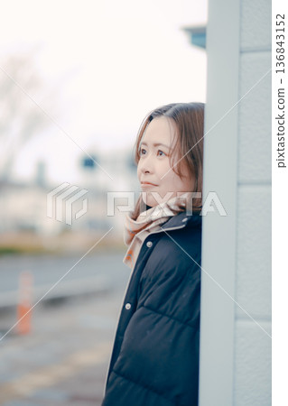 傍晚城市裡，一位沉思的年輕女子 136843152