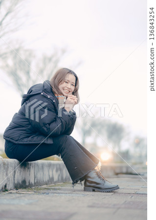 一位二十多歲的日本女子在冬日的城市中微笑 136843254