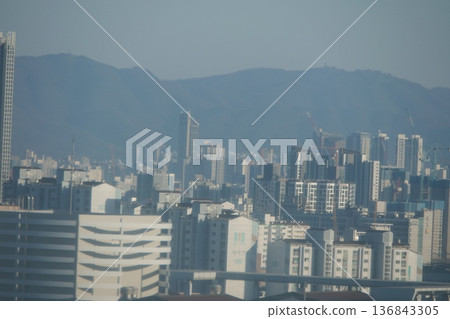 Hazy Korean City Skyline with Mountains and High Rise Apartments 136843305