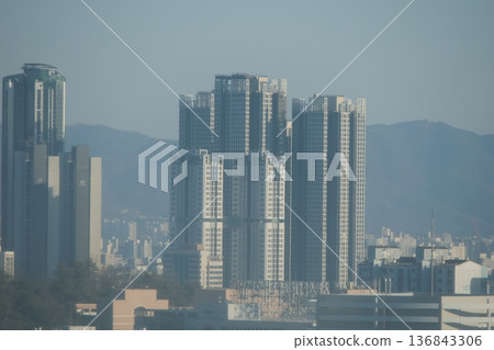 Hazy Korean City Skyline with Mountains and High Rise Apartments 136843306