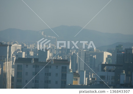 Hazy Korean City Skyline with Mountains and High Rise Apartments 136843307