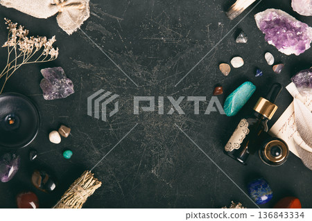 Healing Crystals and Essential Oil on Dark Textured Background 136843334