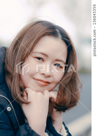 A Japanese woman in her twenties lost in thought in a winter city 136843359