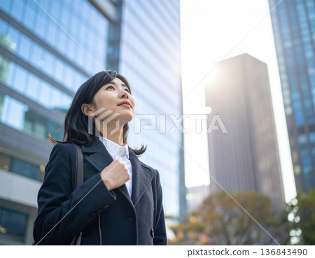 Woman in casual clothes looking up at the sky, steps towards the future Woman in casual clothes looking up at the sky, steps towards the future 136843490
