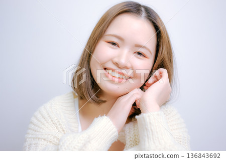A Japanese woman in her twenties smiling on a white background 136843692