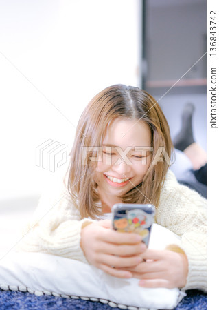 一位二十多歲的日本女性手持智慧型手機 136843742