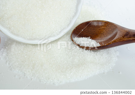 Sugar in bowl with spoon captured from above illustrating portion control and mindful eating habits. Sugar in bowl with spoon captured from above illustrating portion control and mindful eating habits. 136844002
