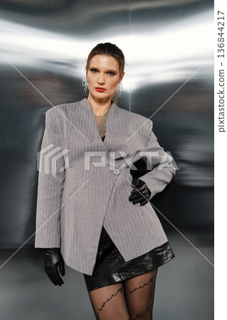 Model poses in a stylish outfit with a modern background during a photoshoot event Model poses in a stylish outfit with a modern background during a photoshoot event 136844217