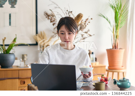 Busy woman eating breakfast 136844225