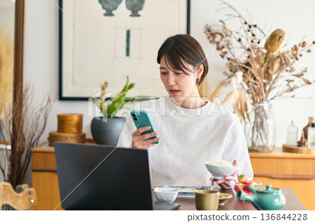 Busy woman eating breakfast Busy woman eating breakfast 136844228