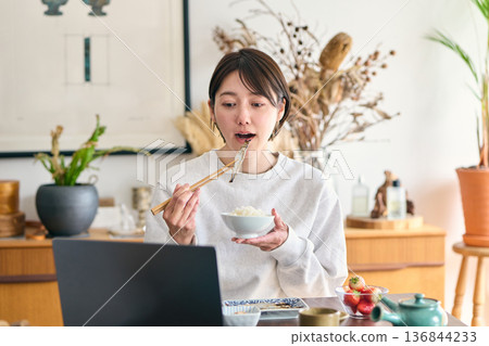 忙碌的女士正在吃早餐 136844233