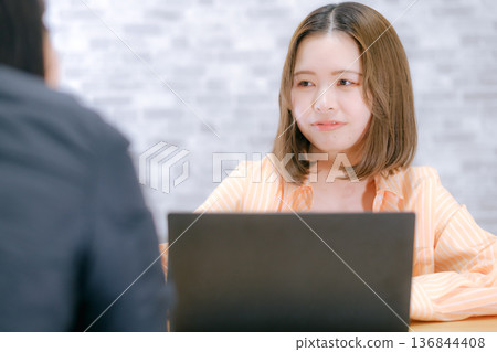 A Japanese woman in her twenties consulting in front of a laptop A Japanese woman in her twenties consulting in front of a laptop 136844408