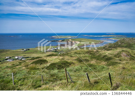 Scenic view of the Irish coast, with islands in the distance, under a bright blue sky. Scenic view of the Irish coast, with islands in the distance, under a bright blue sky. 136844446