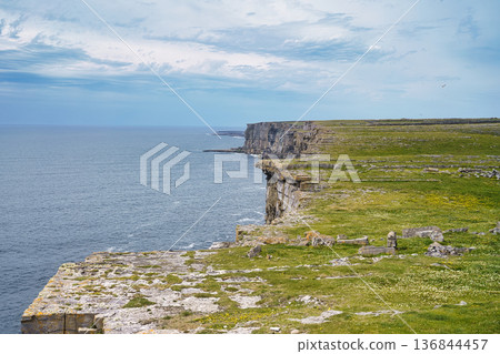 Dramatic coastal cliffs meet the ocean under a cloudy sky in Ireland. Dramatic coastal cliffs meet the ocean under a cloudy sky in Ireland. 136844457