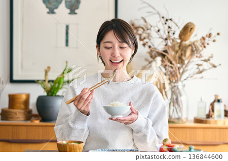 A woman eating Shishamo for breakfast A woman eating Shishamo for breakfast 136844600