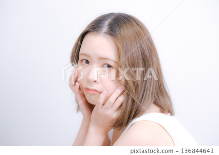 一位二十多歲的日本女性在白色背景前擺姿勢拍照。 136844641