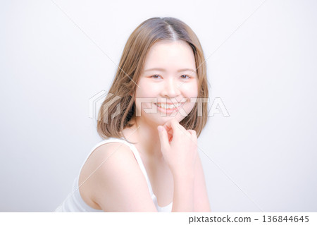 一位二十多歲的日本女性在白色背景前擺姿勢拍照。 一位二十多歲的日本女性在白色背景前擺姿勢拍照。 136844645