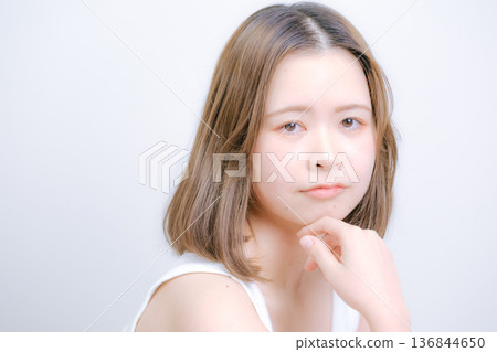 一位二十多歲的日本女性在白色背景前擺姿勢拍照。 136844650