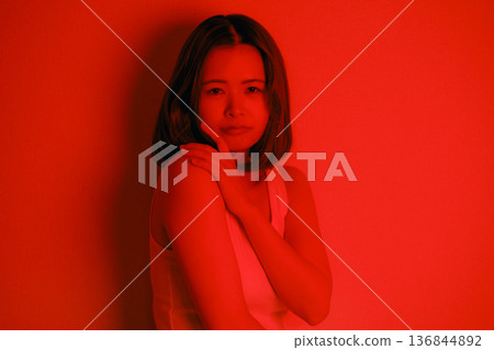 A Japanese woman in her twenties surrounded by red light A Japanese woman in her twenties surrounded by red light 136844892