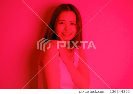 A Japanese woman in her twenties surrounded by red light 136844893