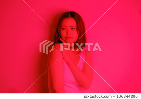 A Japanese woman in her twenties surrounded by red light A Japanese woman in her twenties surrounded by red light 136844896