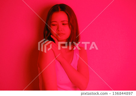 A Japanese woman in her twenties surrounded by red light 136844897