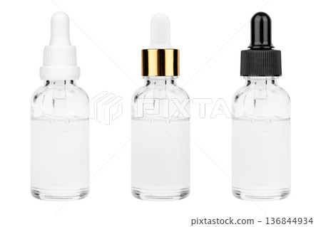 Glass bottle with cuticle oil and facial serum isolated on white background Glass bottle with cuticle oil and facial serum isolated on white background 136844934