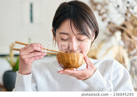 A woman drinking miso soup A woman drinking miso soup 136845293